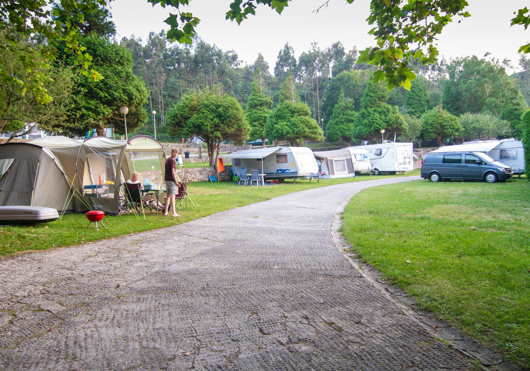 Vista interior del camping con caravanas, tiendas de campaña y vehículos